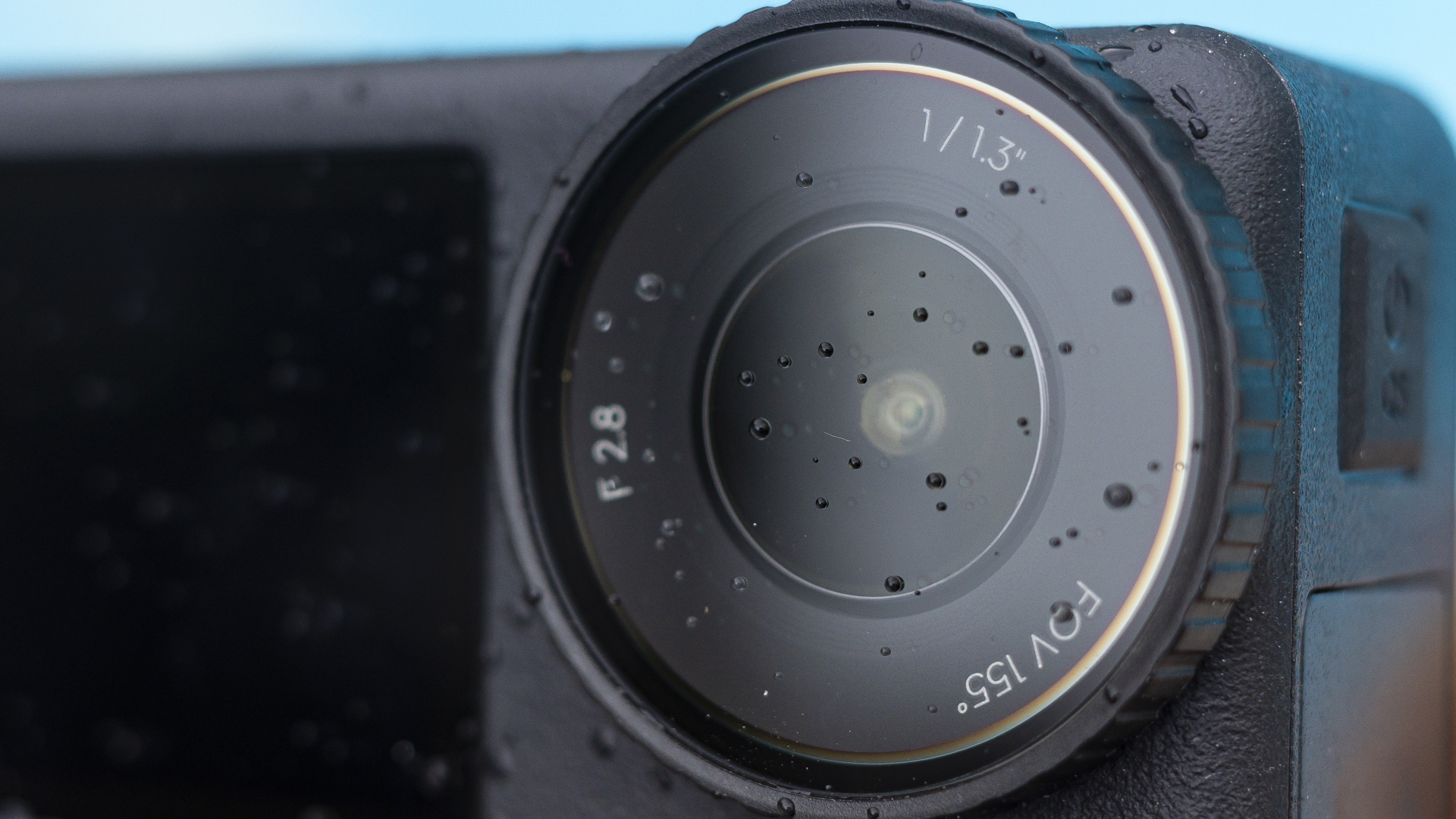 DJI Osmo Action 4 camera closeup of lens by a pool with water droplets on it