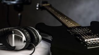 Headphones next to electric guitar 