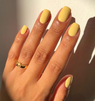 Butter yellow nail polish on short square nails