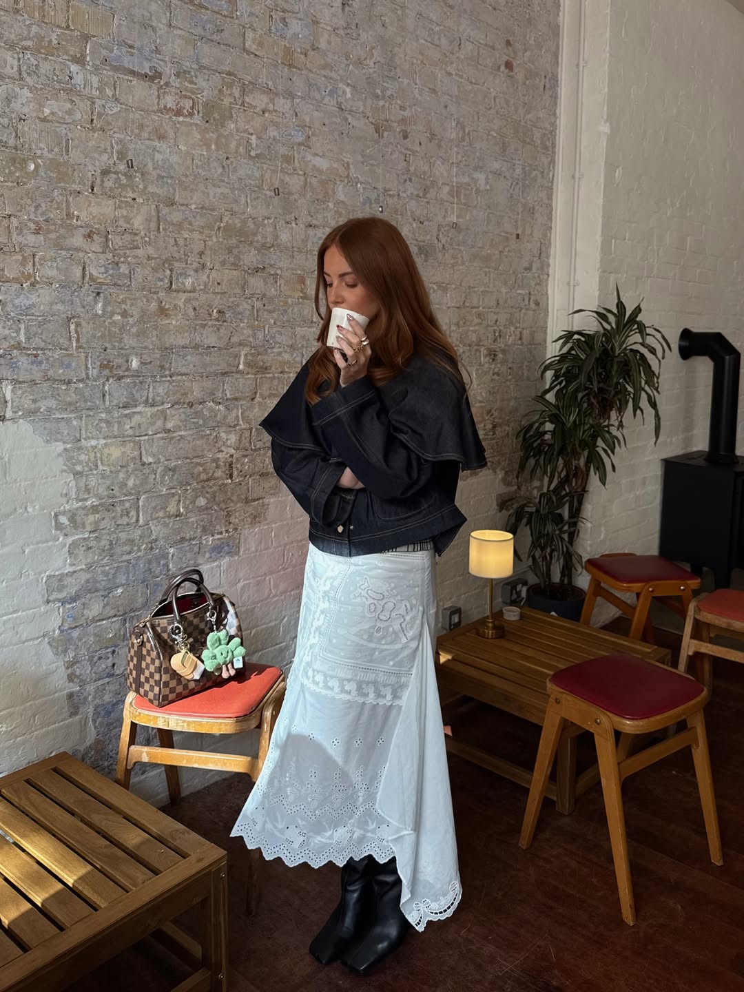 Influencer Rebecca Ferraz Wyatt wearing a denim jacket, lace skirt and knee-high boots.