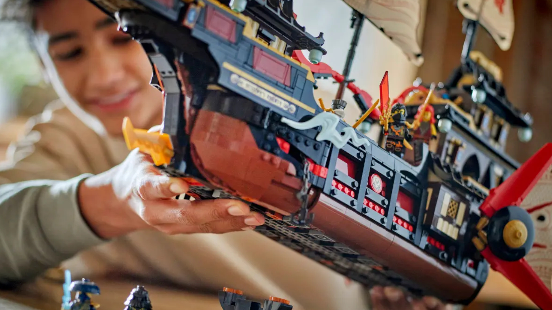 A smiling boy holds up the Lego Temple Bounty boat