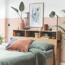 Dusky pink and white bedroom with a wooden headboard that has integrated storage