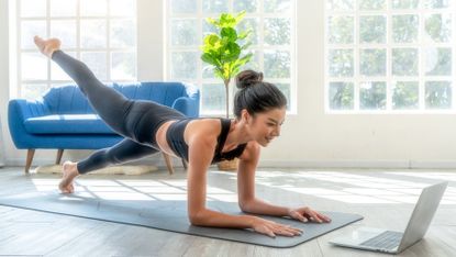 Woman completes a Pilates workout in her living room