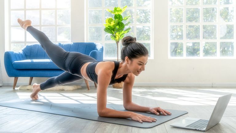 Woman completes a Pilates workout in her living room