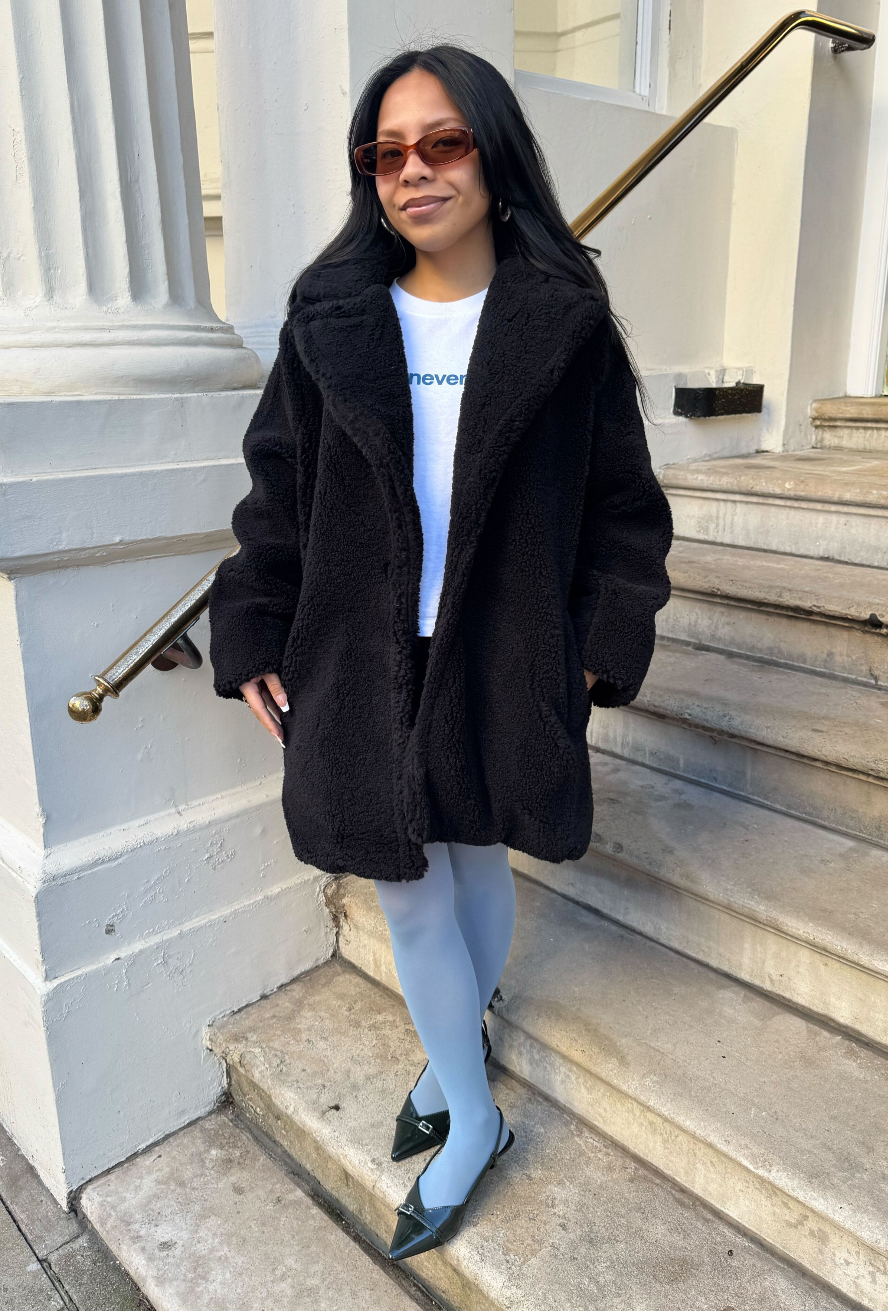 An editor from Who What Wear UK modelling a teddy coat.