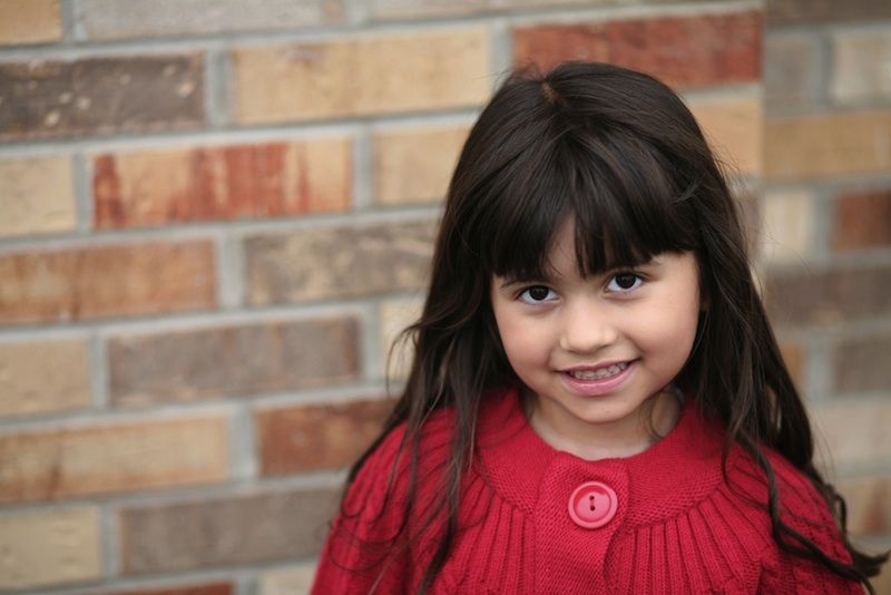 A Latina child smiles.