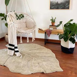 A leaf-shaped rug in a neutral-toned living room