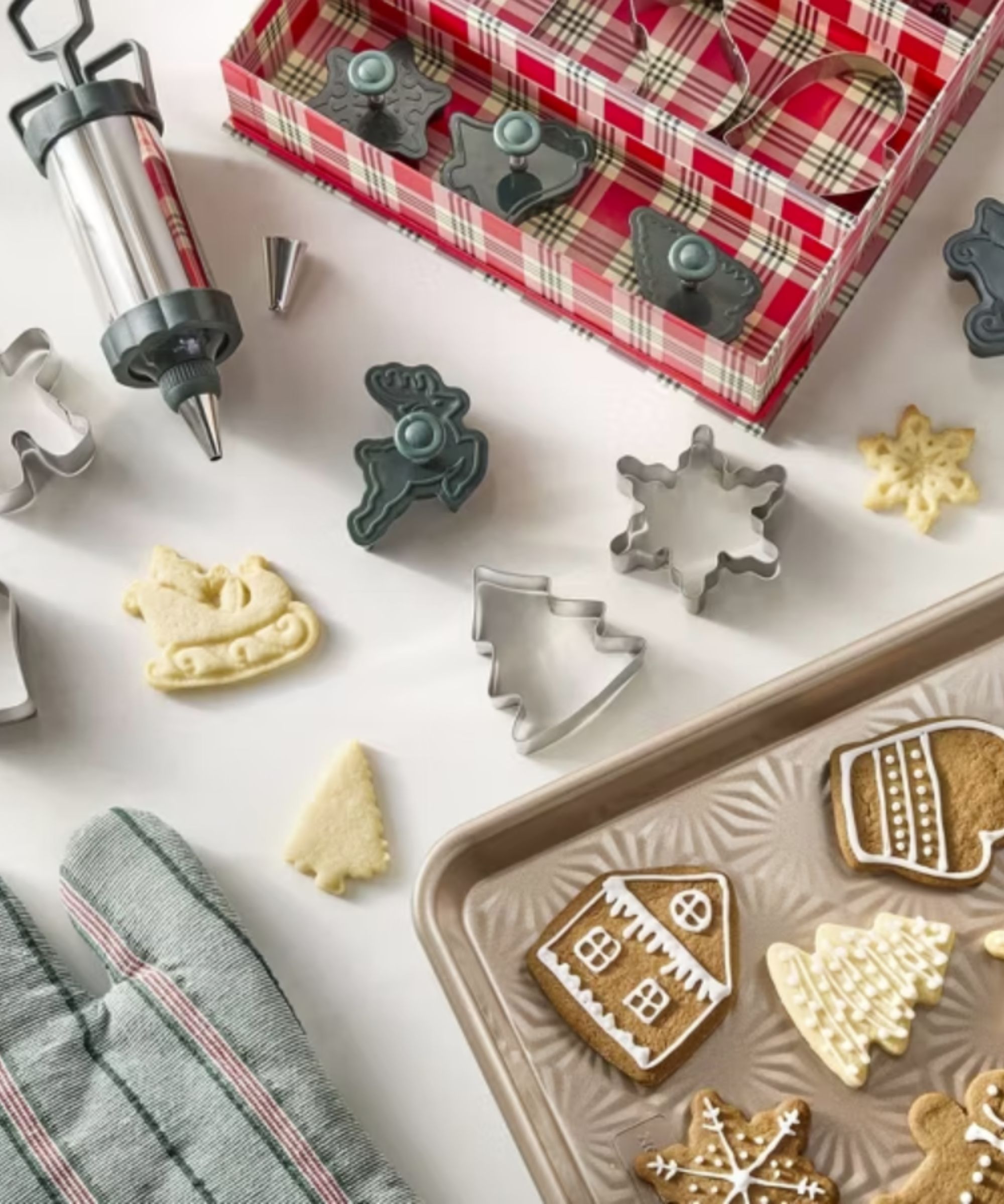 Cookie cutter and icing set with a baking tray of cookies and oven glove