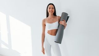 a photo of a woman holding an exercise mat