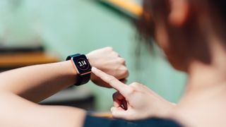 A woman looks at her fitness tracker