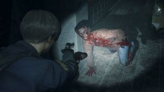 Best horror games - Resident Evil 2 remake screenshot of Leon aiming his gun and flashlight at a bloodied zombie