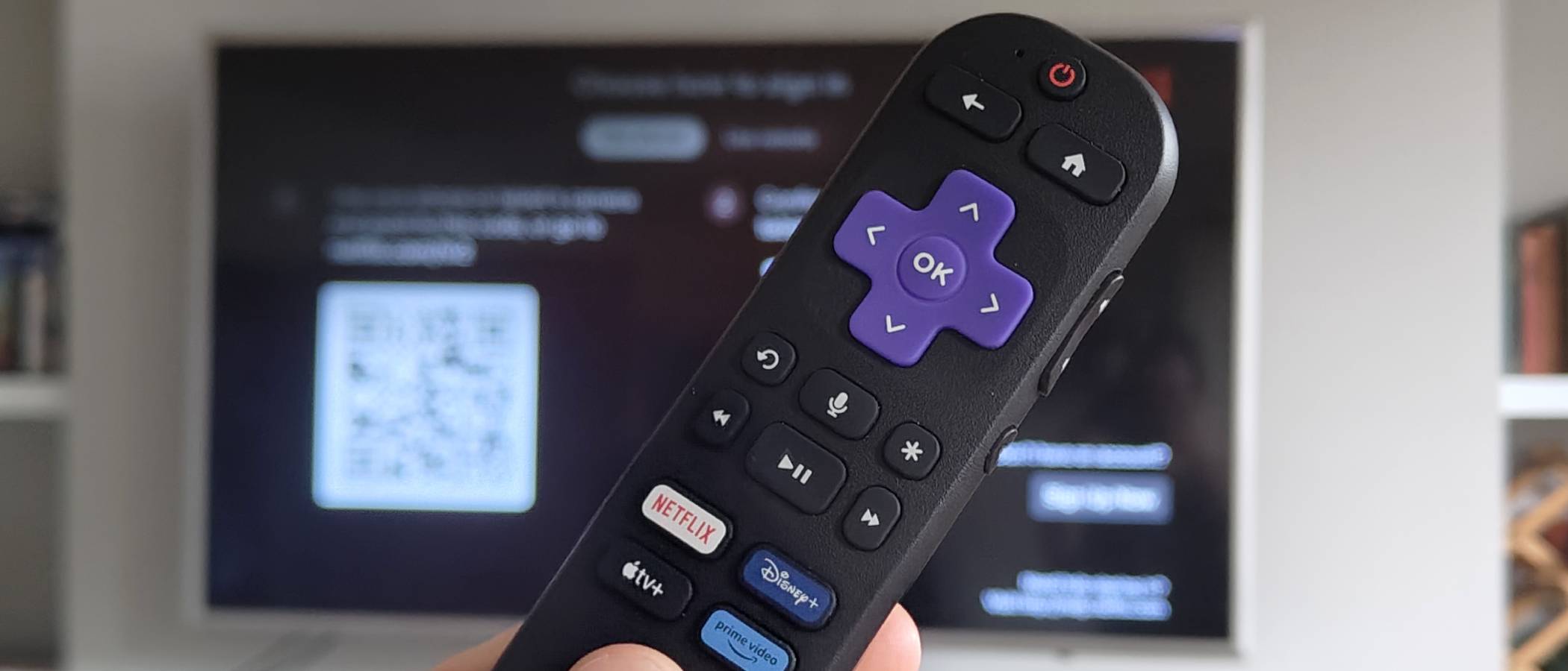 The Roku Streaming Stick remote in front of a TV with Netflix.