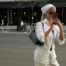 a woman wearing a white shirt and black handbag