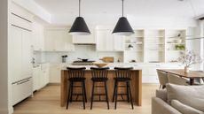 A spacious open concept kitchen with white cabinets, counters and cupboards