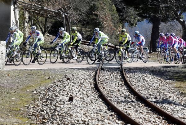 The peloton crosses a rusty railway line