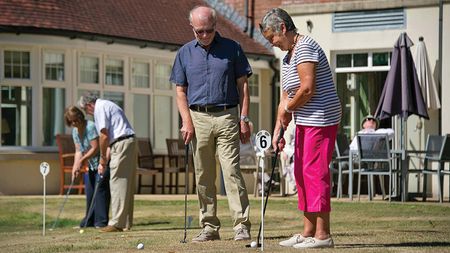 Old people playing mini golf