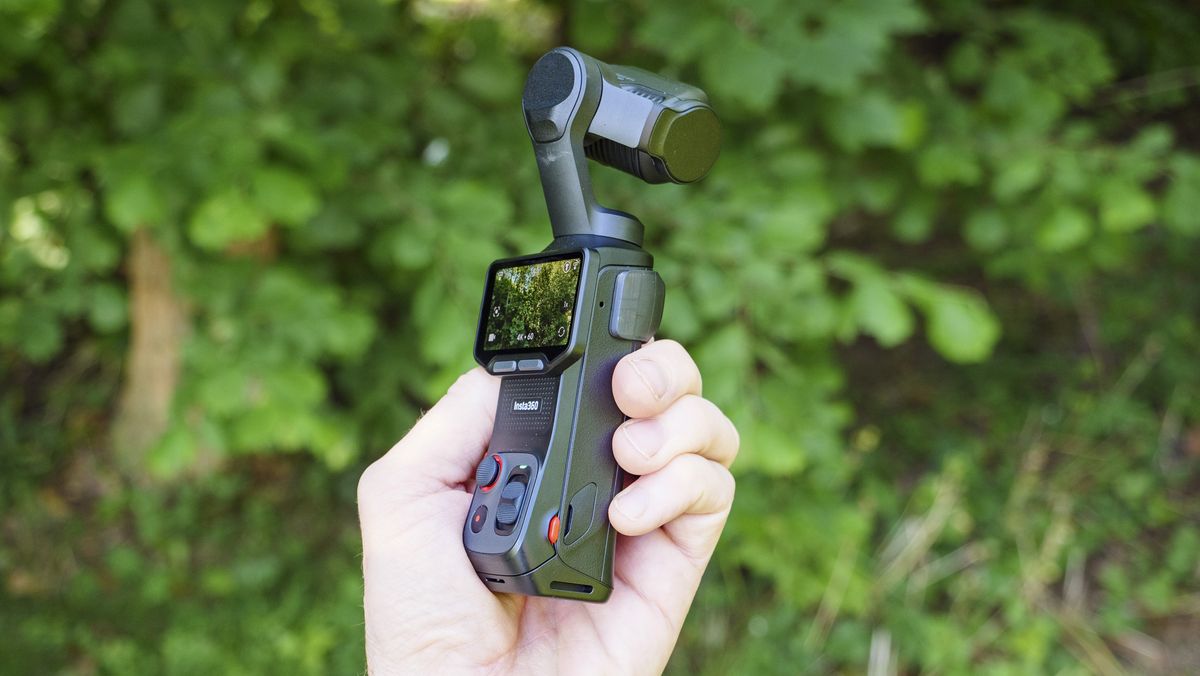 Insta360 Luna Ultra vlogging camera in person's hand, screen rotated and 4K 60p video active, leafy background
