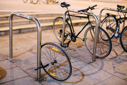 A wheel attached to a bike rack missing its frame