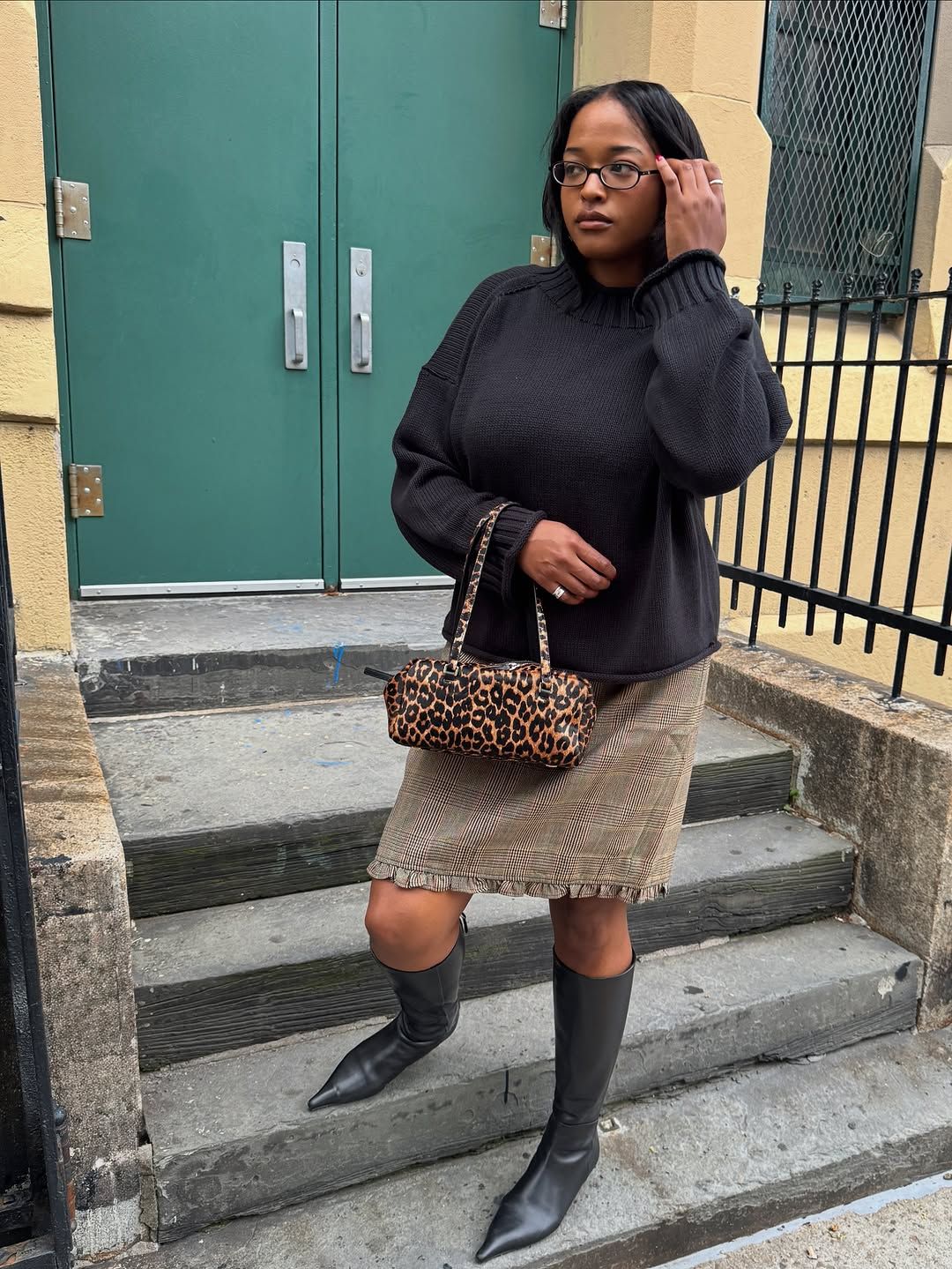 Woman wearing fall boots with skirt outfit 2025.