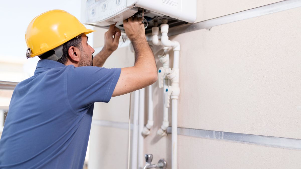 Boiler technician working in home.