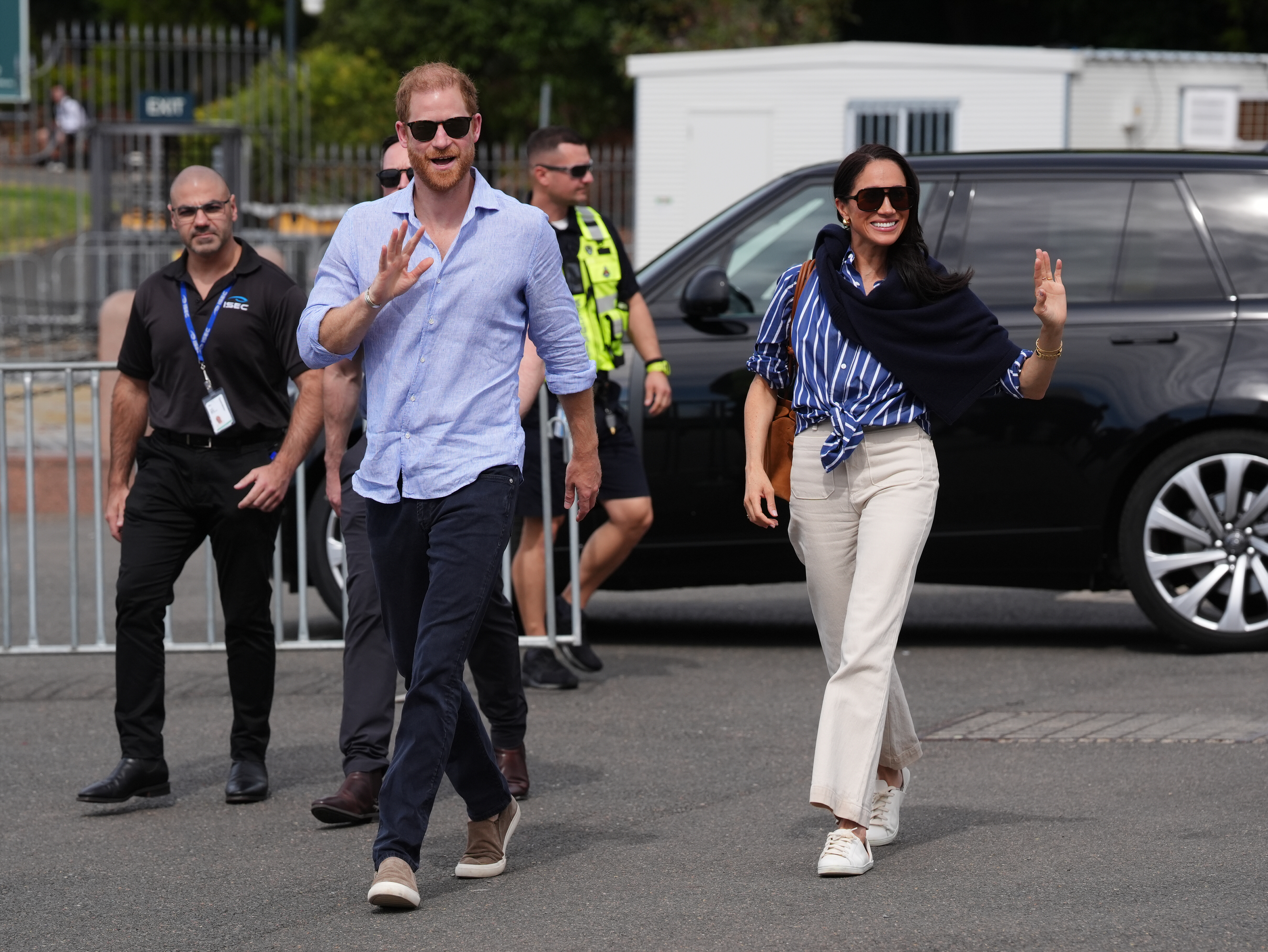Meghan Markle and Prince Harry walking and waving