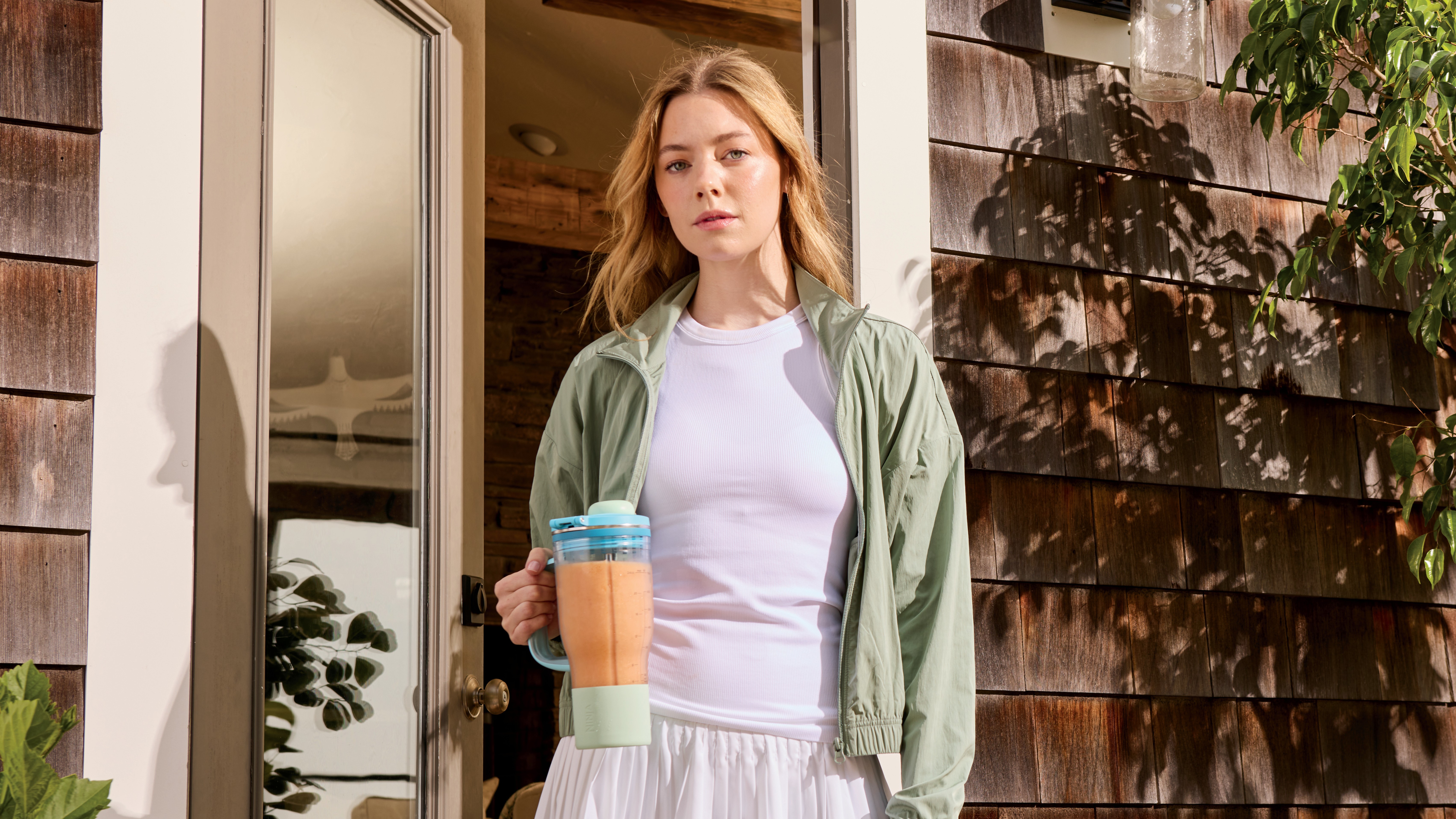 Woman holding Ninja BlendBoss blender cup full of blended smoothie