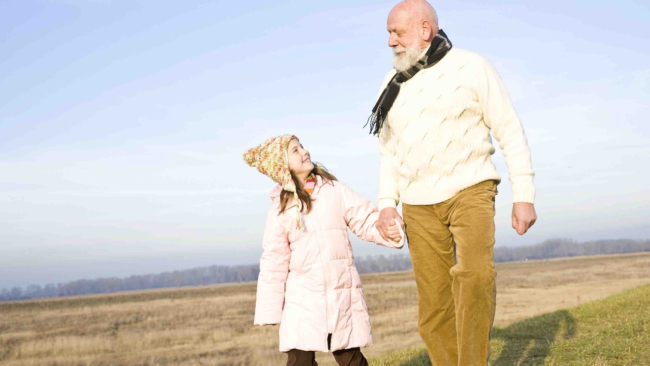 Photo of a young girl holding hands with an older man