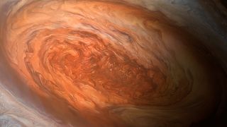 artist's illustration jupiter great red spot close up showing swirls of rusty red and orange in an oval shape. 