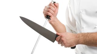 Someone holding a knife and a honing steel