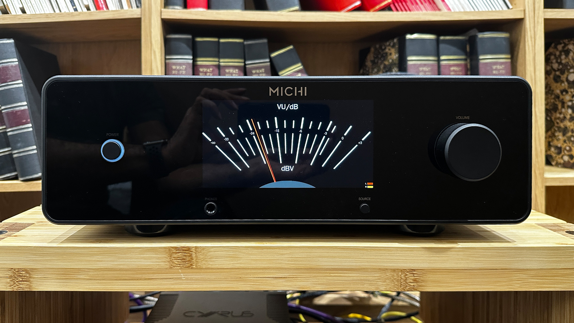 Rotel Michi Prestige X430 integrated amplifier on wooden hi-fi rack in front of bookcase
