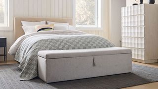 a modern bedroom with a storage ottoman