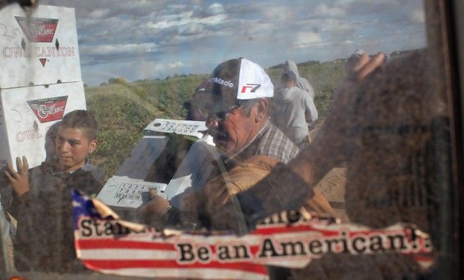 Migrant workers load boxes onto a truck in Wellington, Colo.