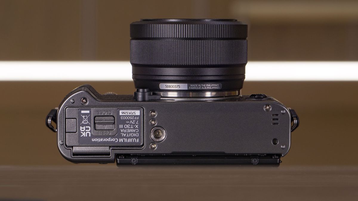 Underside of the Fujifilm X-T30 III camera on a glass table