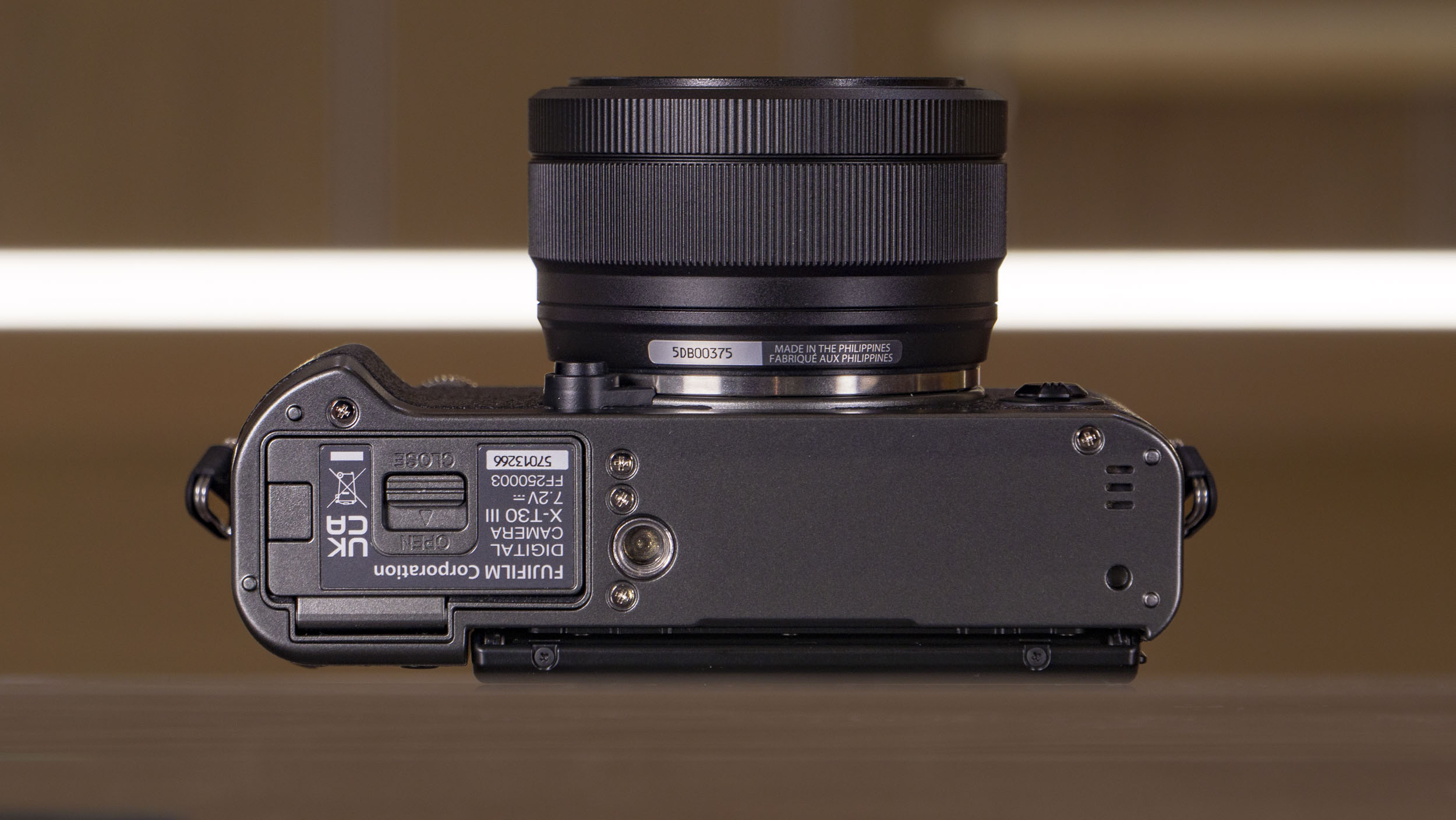 Underside of the Fujifilm X-T30 III camera on a glass table