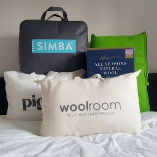 A selection of duvets in their packaging on a bed in a bedroom