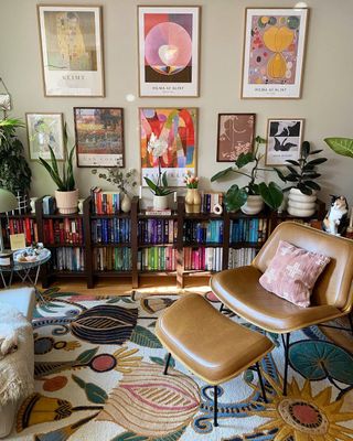 A living room with a colorful bookshelf and wall art