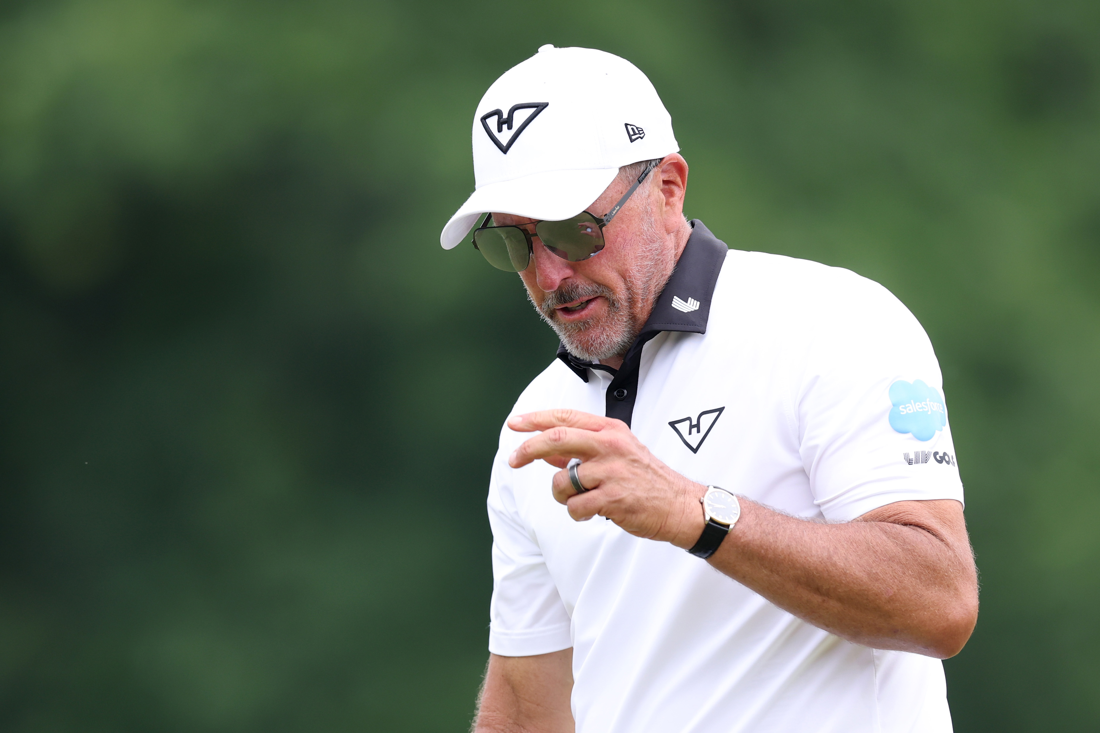 Phil Mickelson looks at his golf ball