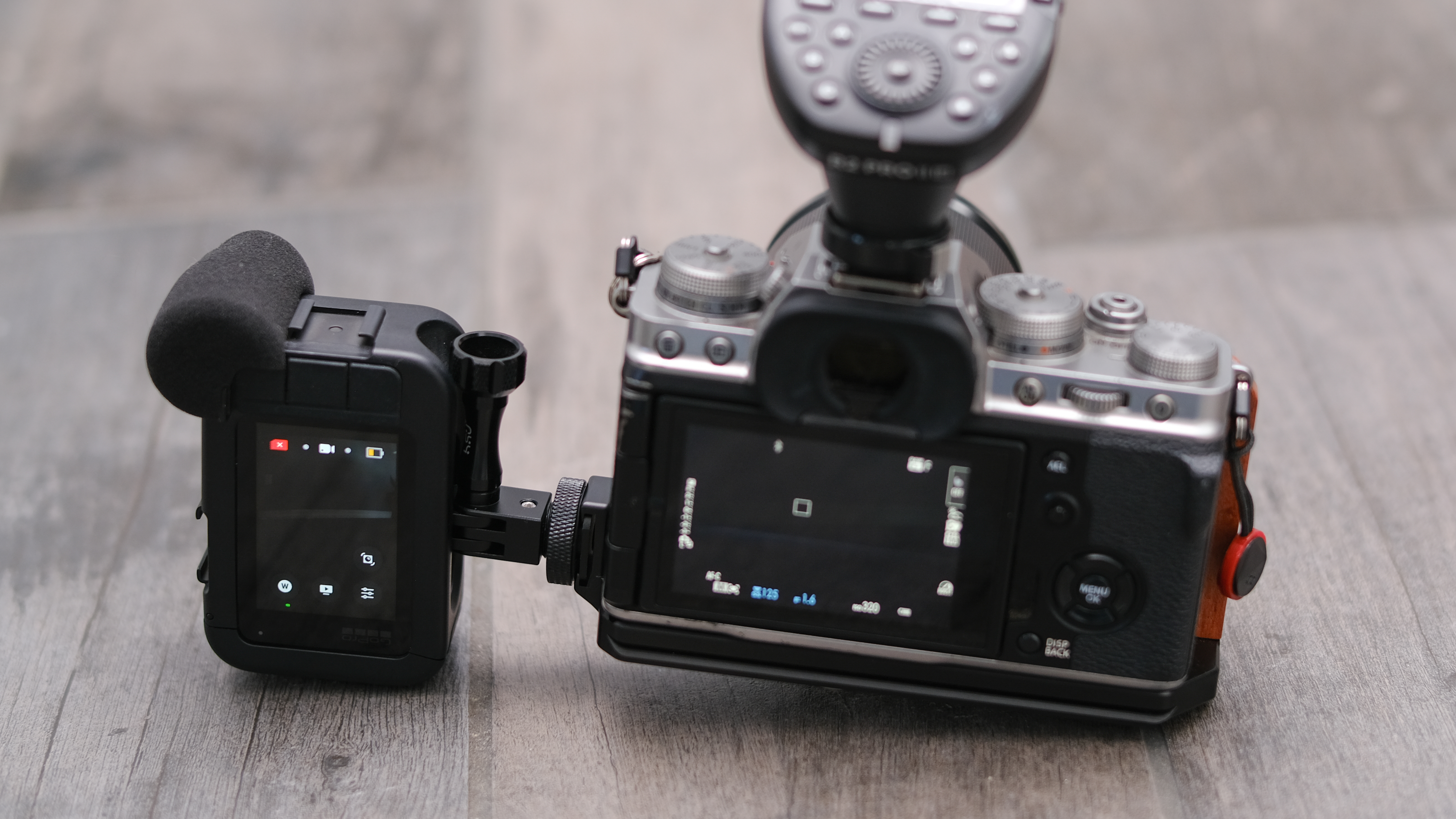 A GoPro sits mounted sidewise on a Fujifilm X-T4