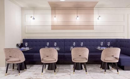 The Fritz interior purple banquette seating, blush tub chairs and marble floor tiles