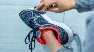 How to look after your trainers during winter - Woman cleaning her running shoes