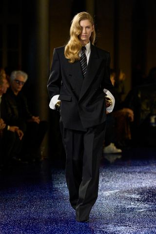 A Saint Laurent runway model wearing an all-black outfit in the spring/summer 2025 collection.