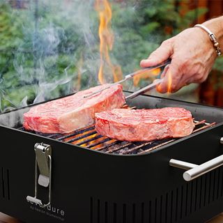 Everdure Cube BBQ in black with steaks on