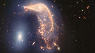 A JWST photo showing a galaxy in the shape of a penguin