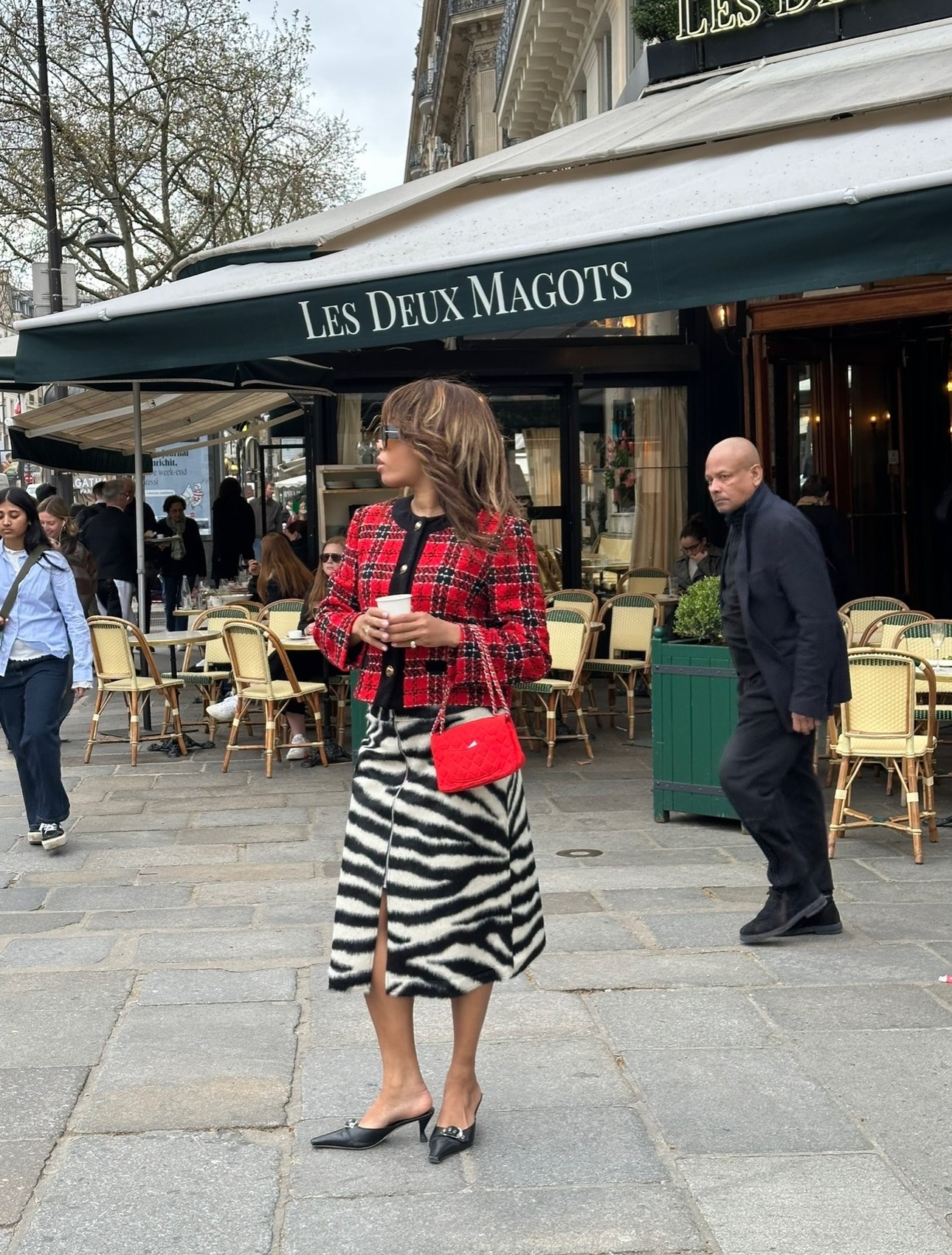 A woman in Paris wearing a tartan jacket with brunette hair and honey blonde highlights
