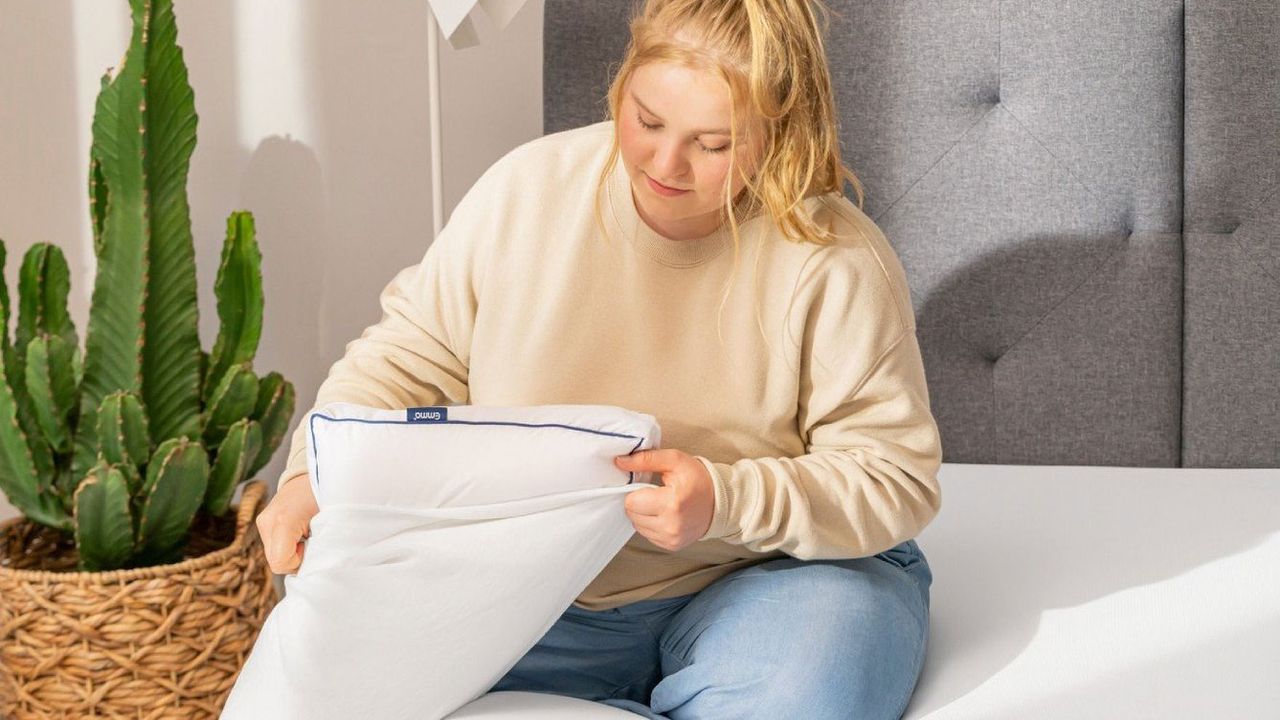 Woman putting a pillowcase over the Emma Premium Microfibre Pillow