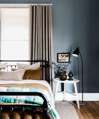 bedroom with black wrought iron bed and blue gray walls