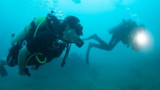 Scuba divers dive to the site of the Godawaya shipwreck