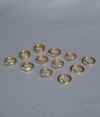Selection of gold diamond rings against a grey backdrop