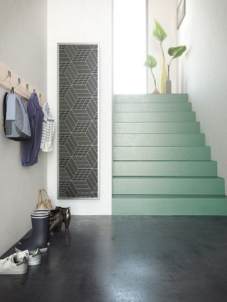 green painted staircase with radiators and coat hooks