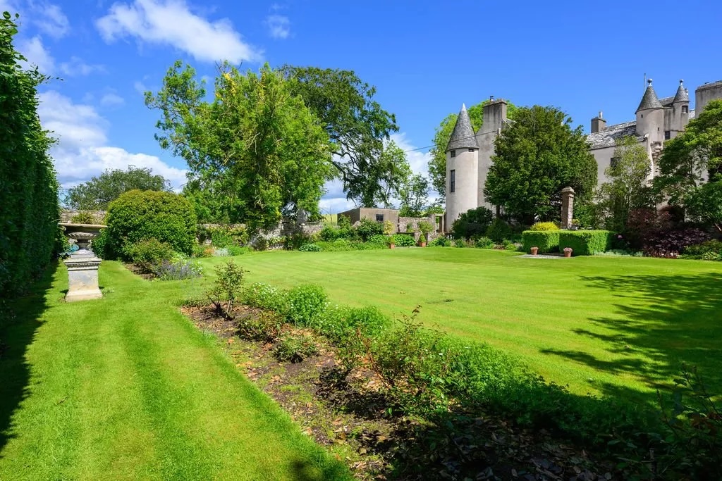 A view of the castle from the lawned garden, which is boundaried by hedges